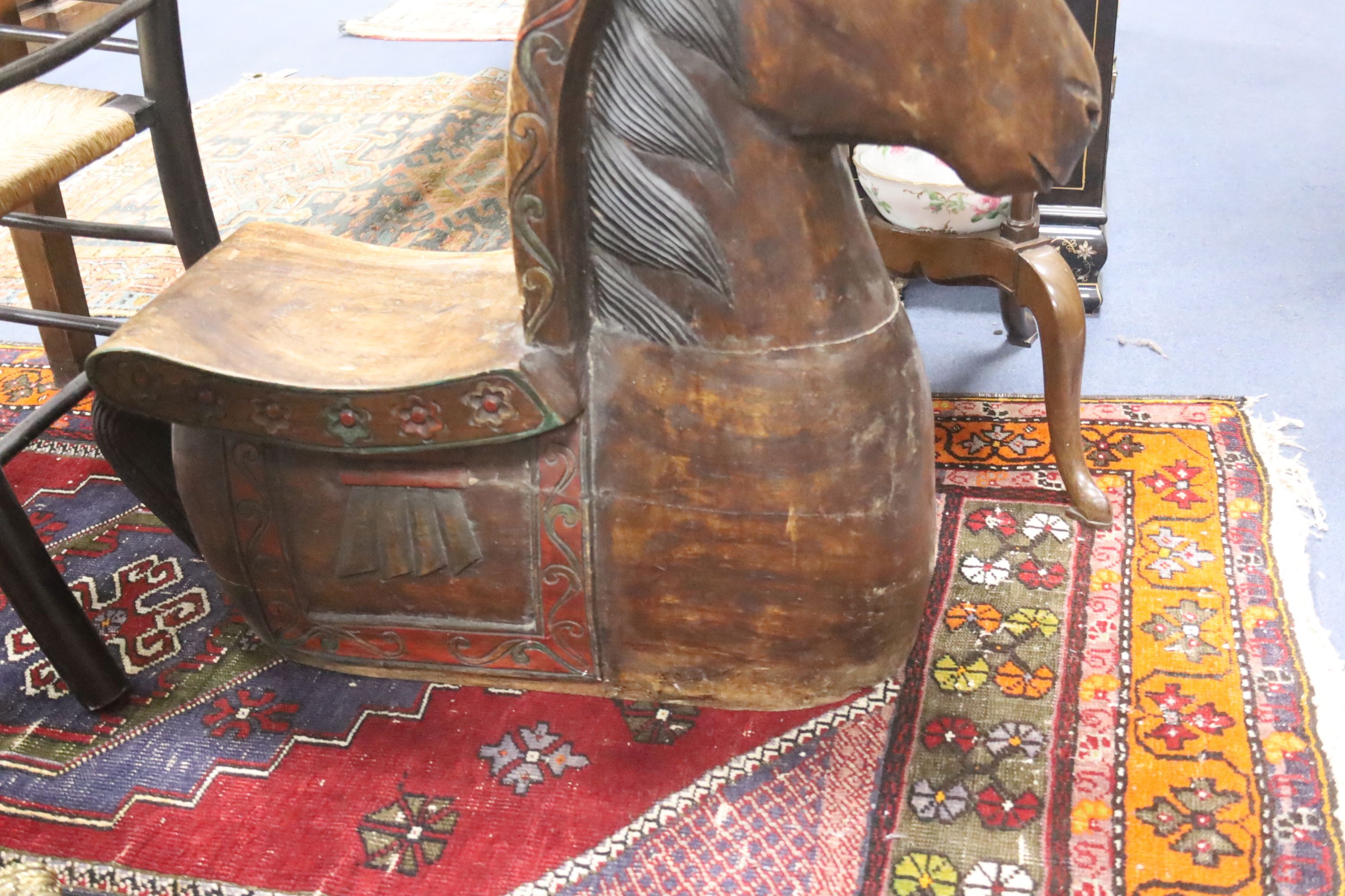 A large decorative carved hardwood horse shaped stool, 60cm. long. 26cm. wide. 72cm. high.